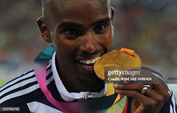 Gold medallist Britain's Mohammed Farah poses during the award ceremony for the men's 5,000 metres event at the International Association of...