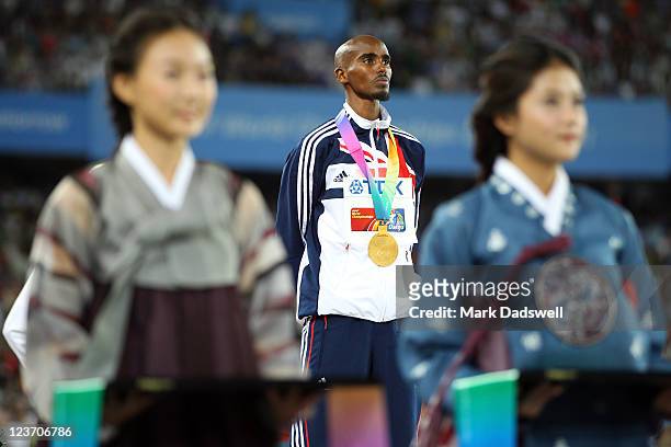 Mohamed Farah of Great Britain stands with his gold medal during the medal ceremony for the men's 5000 metres final during day nine of 13th IAAF...