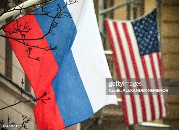 Russian flag flies next to the US embassy building in Moscow on December 7 on a snowy day. - Russian President Vladimir Putin and US President Joe...