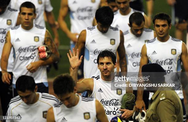 Argentine footballer Lionel Messi gestures to supporters following a training session in Kolkata on September 4, 2011. Argentine captain Lionel Messi...