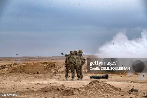 Soldier fires an anti-tank missile while a javelin surface-to-air missile launcher is seen on the ground, during a joint military exercise between...