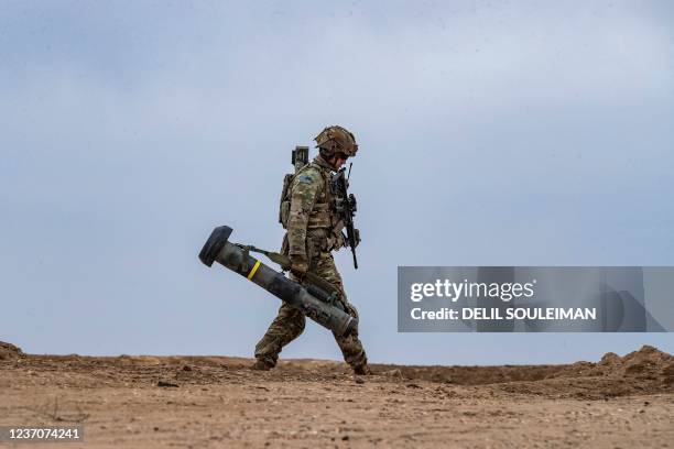 Soldier walks with a javelin surface-to-air missile launcher during a joint military exercise between the Syrian Democratic Forces and the US-led...