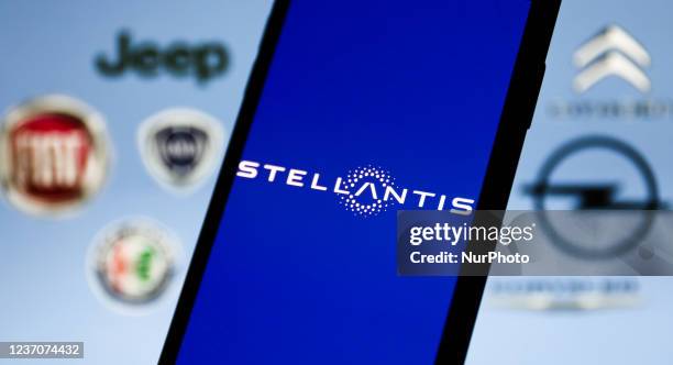 Stellantis logo displayed on a phone screen is seen with some of the company brands logos displayed in the background in this illustration photo...