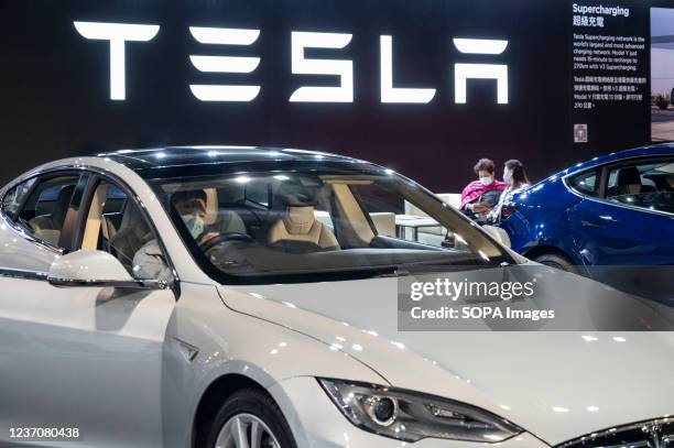 Visitor tests and sits in a Tesla model S at the American electric company car Tesla Motors booth during the International Motor Expo showcasing...