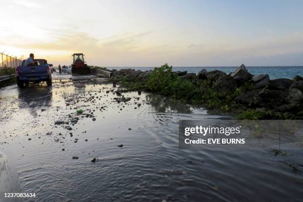 Photo taken on December 5, 2021 shows high-tide flooding and debris covering the road to the airport in the Marshall Islands capital Majuro. - A...