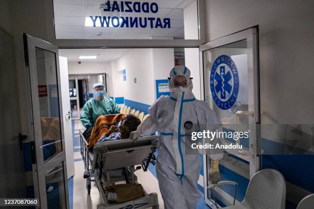 Medical personnel wear personal protective equipment as they transport a COVID -19 unvaccinated patient inside the Emergency Ward converted to a...
