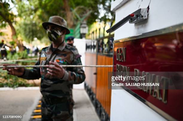 Security personnel stand guard outside the entrance of defence chief General Bipin Rawat's house in New Delhi on December 8, 2021. - A helicopter...