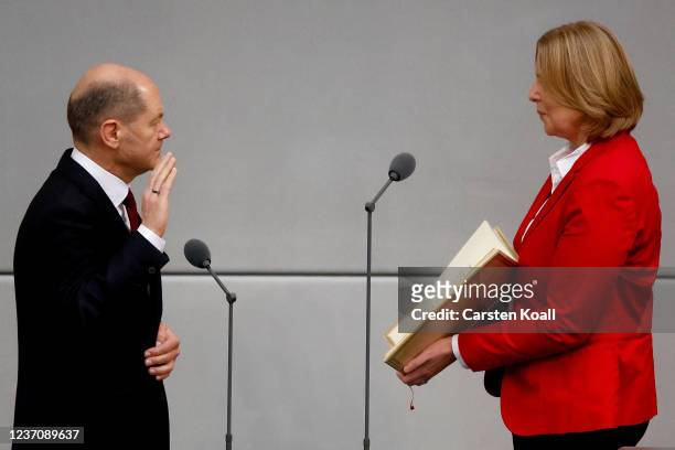 New German Chancellor Olaf Scholz takes his oath of office from Bundestag President Baerbel Bas during a ceremony at the Bundestag, Germany's...