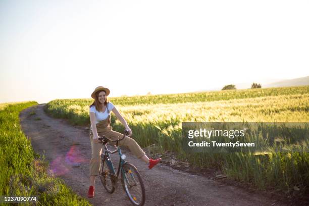 woman riding a bicycle in nature - grama de ponta imagens e fotografias de stock