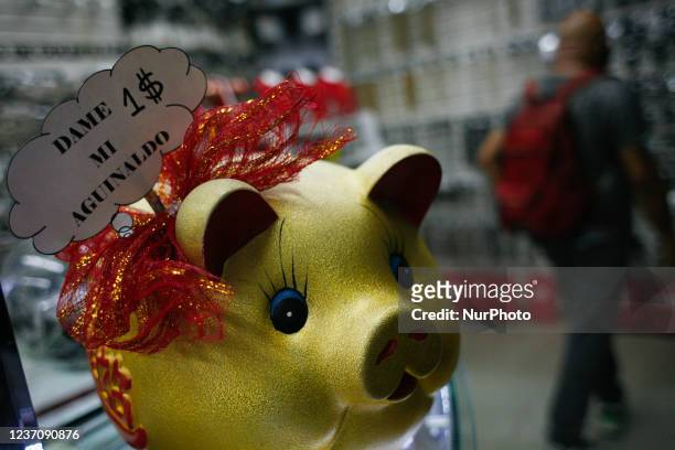 Detail of a piggy bank to receive tips, which says in Spanish: give me my Christmas bonus, in a store in the west of the city, in the middle of the...
