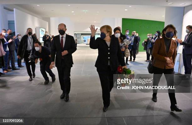 German Chancellor Olaf Scholz accompanies his predecessor Angela Merkel to the exit of the Chancellery as she bids farewell to chancellery workers...