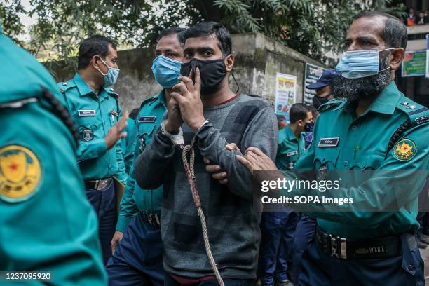 Police officers escort one of the 20 convicted university students out of court after their sentence to death for the brutal 2019 murder of a young...