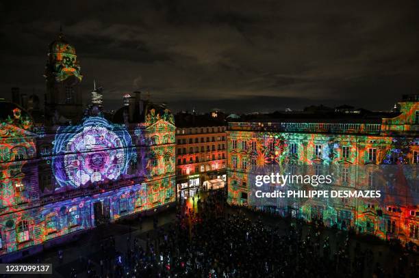 People look at the town hall and the Modern Art museum illuminated on "Les Terreaux" square during the Festival of Lights , in Lyon central eastern...