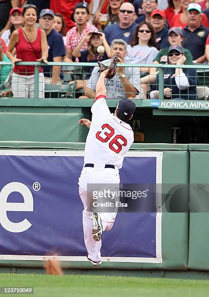 Conor Jackson of the Boston Red Sox runs into the wall chasing a hit by Ian Kinsler of the Texas Rangers on September 4, 2011 at Fenway Park in...
