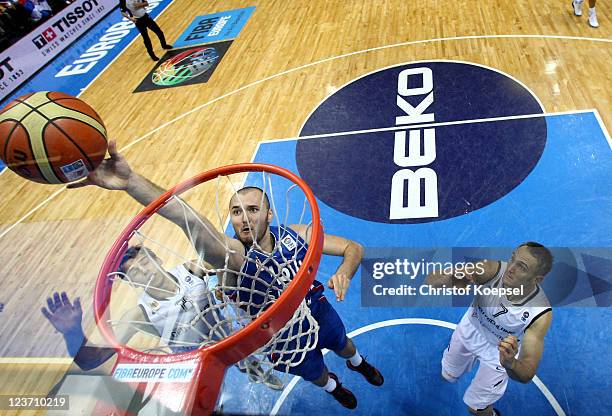 Milan Macvan of Serbia scores against Lucca Staiger of Germany and Sven Schultze of Germany the EuroBasket 2011 first round group B match between...