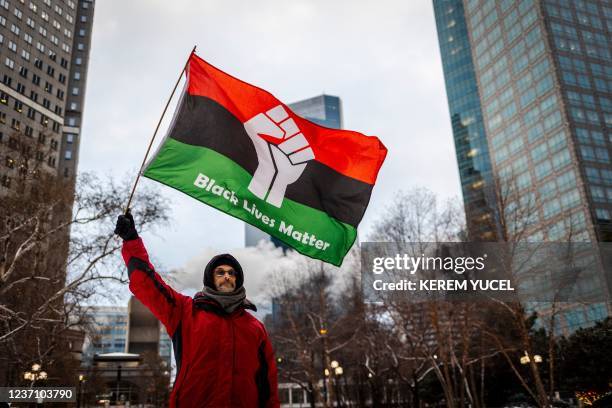 Keith McCarron, waves a Black Lives Matter flag outside the Hennepin County Government Center as the trial of former Brooklyn Center police officer...