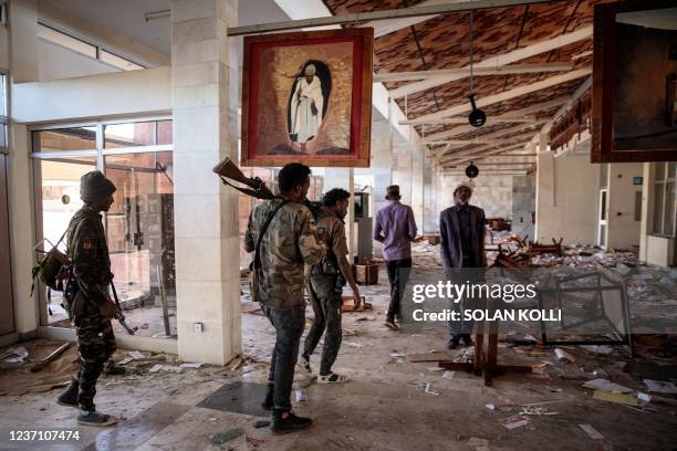 Amhara Fano militia fighters walk in the ransacked terminal at the Lalibela airport in Lalibela, on December 7, 2021. - Residents of Lalibela, a city...