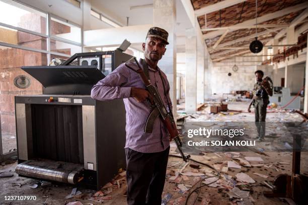 Amhara Fano militia fighters walk in the ransacked terminal at the Lalibela airport in Lalibela, on December 7, 2021. - Residents of Lalibela, a city...