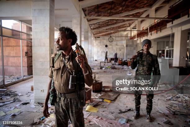 Amhara Fano militia fighters walk in the ransacked terminal at the Lalibela airport in Lalibela, on December 7, 2021. - Residents of Lalibela, a city...