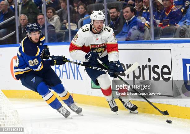 Florida Panthers center Carter Verhaeghe skates with the puck with pressure from St. Louis Blues center Jordan Kyrou during a NHL game between the...