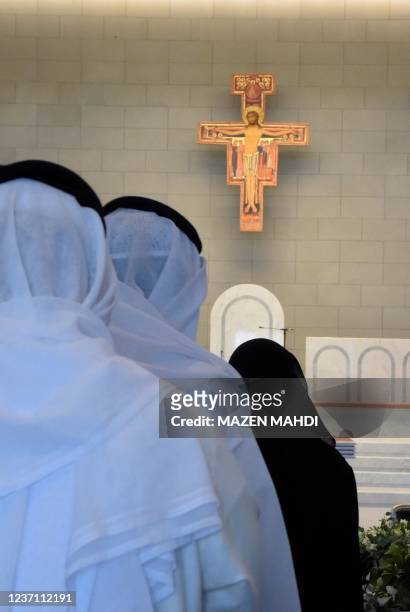 People attend attend the opening of Our Lady of Arabia Cathedral during its inauguration in Awali south of the Bahraini capital Manama on December 9,...