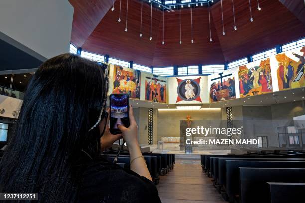 Woman takes pictures of the Our Lady of Arabia Cathedral in Awali, south of the Bahraini capital Manama, on December 8, 2021. - The church, which...