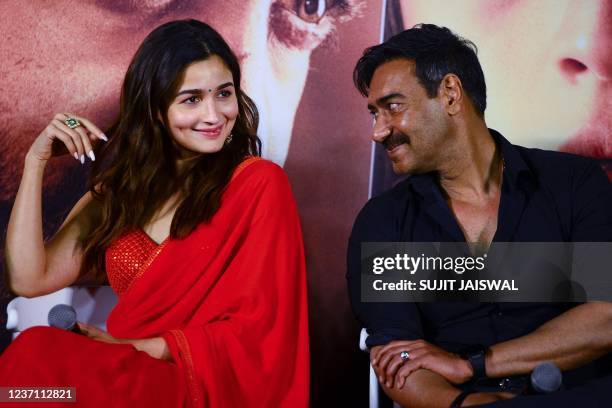 Bollywood actors Ajay Devgn and Alia Bhatt pose for a picture during the trailer launch of the upcoming Telugu-language period action drama film...