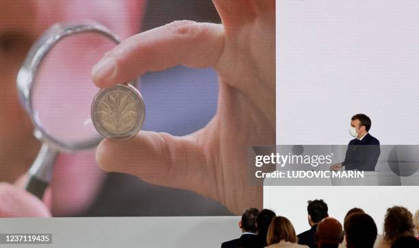 French President Emmanuel Macron presents a new two-Euro-coin marking the French Presidency of the Council of the European Union during a press...