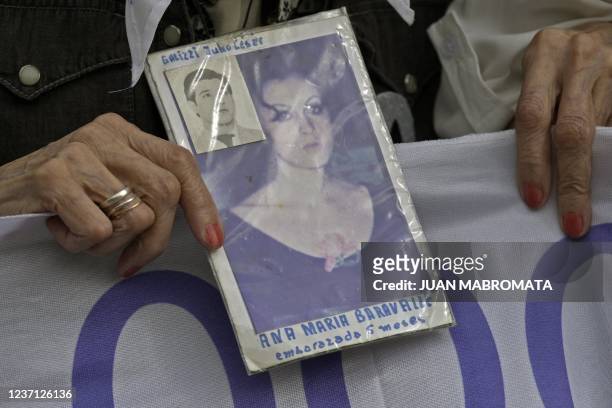 Member of the human rights organization Madres de Plaza de Mayo Linea fundadora Mirta Acuna de Baravalle holds the portrait of her disappeared...