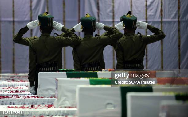Indian Army officers salute next to the coffins containing the mortal remains of India's Armed Forces personnel who lost their lives in an Indian Air...