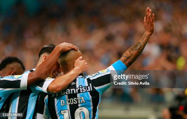 Douglas Costa of Gremio celebrates with teammates after scoring the fourth goal of their team during the match between Gremio and Atletico Mineiro as...