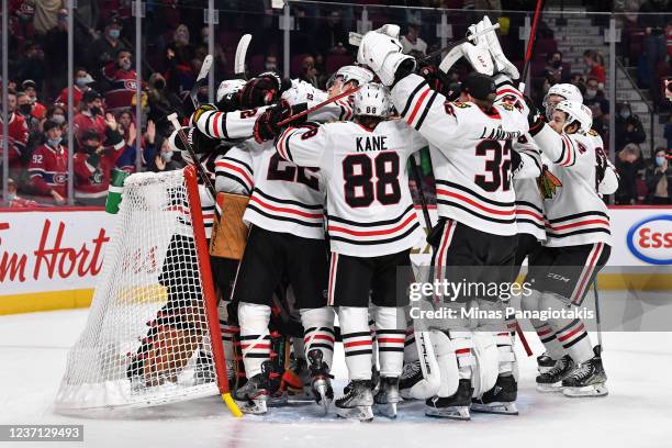 Members of the Chicago Blackhawks rush goaltender Marc-Andre Fleury after winning his 500th career NHL win during the match against the Montreal...