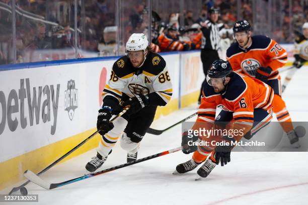 Kris Russell of the Edmonton Oilers defends against David Pastrnak of the Boston Bruins during the first period at Rogers Place on December 9, 2021...