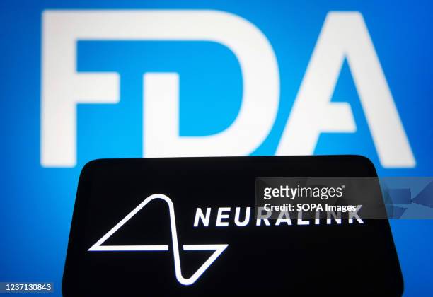 In this photo illustration, the logo of Neuralink Corporation, a neurotechnology company is seen on a smartphone screen and FDA logo is seen in the...