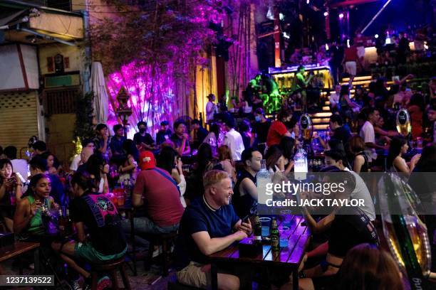 People enjoy a drink at a bar along the popular tourist and nightlife strip Khao San Road in Bangkok on December 10, 2021.