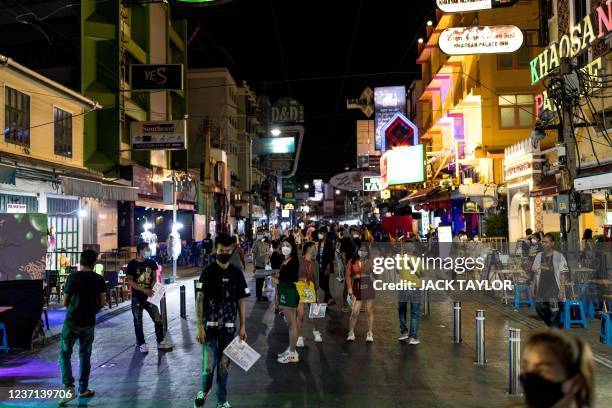 Bar and restaurant workers wait for customers along the popular tourist and nightlife strip Khao San Road in Bangkok on December 10, 2021.