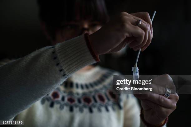 Resident processes a self-administered at-home Covid-19 test, received through a government program, in Easton, New Hampshire, U.S., on Tuesday, Dec....