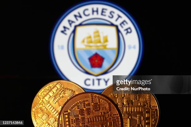 Representation of cryptocurrency is seen with Manchester City football club logo displayed in the background in this illustration photo taken in...