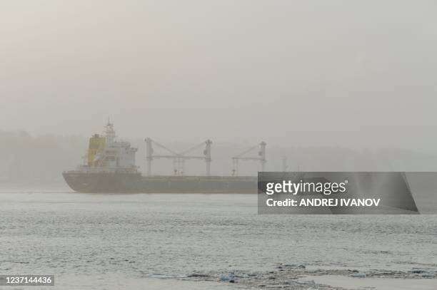 Barge floats down the Saint Lawrence River near the Quai Chouinard as the sun rises over Quebec City and Levis, Quebec on December 9, 2021. - Barges...