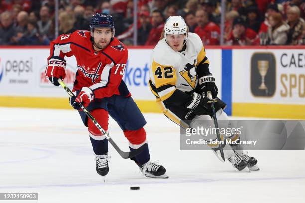 Conor Sheary of the Washington Capitals carries the puck as Kasperi Kapanen of the Pittsburgh Penguins looks to attempt a steal during a game between...