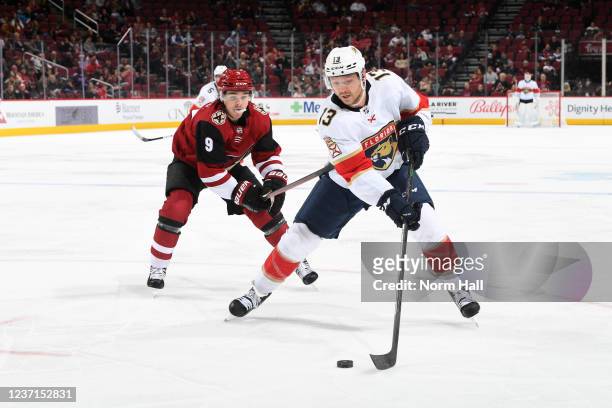 Sam Reinhart of the Florida Panthers skates with the puck while being defended by Clayton Keller of the Arizona Coyotes during the third period at...