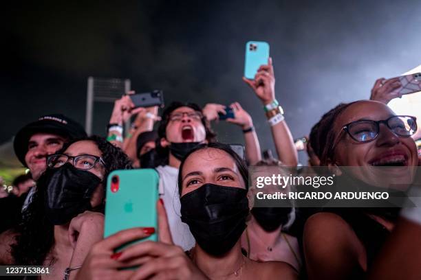 Fans, some wearing face masks, cheer as they watch Puerto Rican rapper Bad Bunny perform live on stage as part of his two-day "P FKN R" concert at...