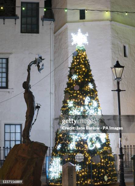 The Christmas tree alongside the statue of naturalist John Muir in the High Street in Dunbar, East Lothian. Picture date: Friday December 10, 2021.
