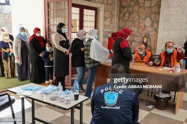 Palestinians are pictured at a polling station during municipal elections in the village of Baitain, East of the occupied West Bank city of Ramallah,...