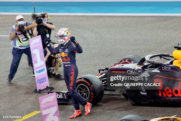 Red Bull's Dutch driver Max Verstappen celebrates in the Parc Ferme of the Yas Marina Circuit after he took the pole position during the qualifying...