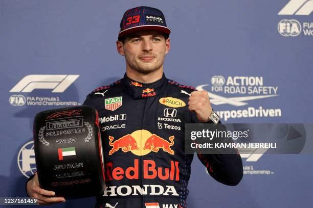 Red Bull's Dutch driver Max Verstappen poses with his award in the Parc Ferme of the Yas Marina Circuit after he took the pole position during the...