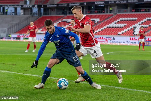 Andrej Kramaric of TSG 1899 Hoffenheim and Nico Schlotterbeck of SC Freiburg battle for the ball during the Bundesliga match between Sport-Club...