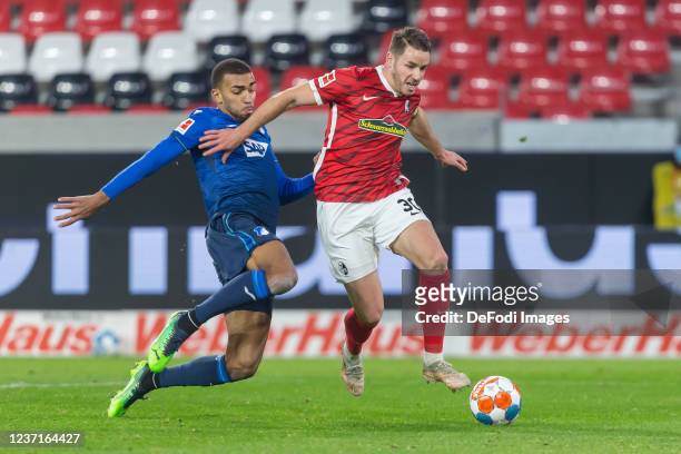 Kevin Akpoguma of TSG 1899 Hoffenheim and Christian Guenter of SC Freiburg battle for the ball during the Bundesliga match between Sport-Club...
