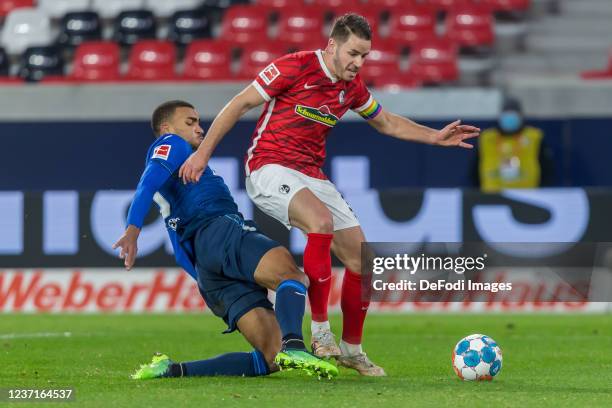 Kevin Akpoguma of TSG 1899 Hoffenheim and Christian Guenter of SC Freiburg battle for the ball during the Bundesliga match between Sport-Club...