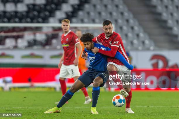 Georginio Rutter of TSG 1899 Hoffenheim and Manuel Gulde of SC Freiburg battle for the ball during the Bundesliga match between Sport-Club Freiburg...